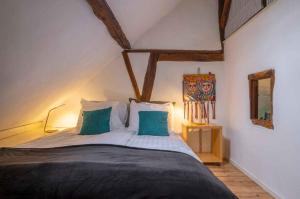 a bedroom with a large bed with blue pillows at Op de Klever in Schimmert