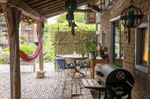 an outdoor patio with a table and chairs at Op de Klever in Schimmert