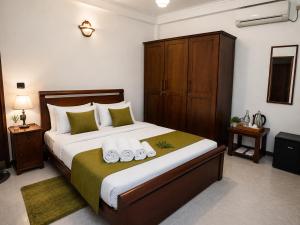 a bedroom with a bed with two towels on it at Eco Serenity Kandy in Kandy