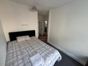 a bedroom with a bed and a white wall at kinsale Central Rooms in Kinsale