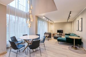 a living room with a table and chairs and a couch at Imanta Garden Townhouses in Riga