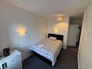 a small bedroom with a bed and two lights at kinsale Central Rooms in Kinsale