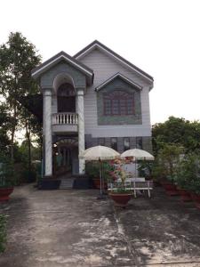 a house with two umbrellas in front of it at Sao Mai Hotel in Cai Be