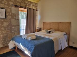 a bedroom with a bed with towels on a blue blanket at Sirona - domaine viticole et chambres d'hôtes in Le Puy-Notre-Dame