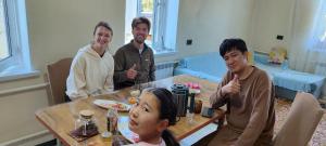 a group of people sitting around a table at Karakol City Center in Karakol