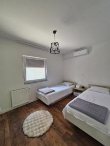 a bedroom with two beds and a window at Little Aria in Ripač +10 photos