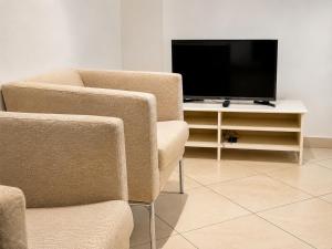 a living room with two chairs and a flat screen tv at Appartement 2 chambres in Moroni