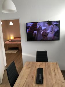 クリニツァ・ズドルイにあるApartament Jaworzyna Krynickaの壁にテーブルとテレビが備わる部屋