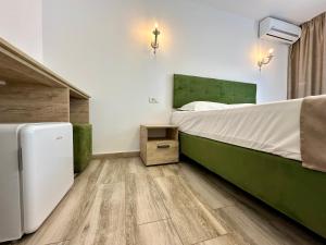 a bedroom with a bed and a refrigerator in it at Hotel Nalba-Dalia Jupiter in Jupiter