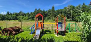 a playground in a field with three play equipment at Pod Lasem in Przewłoka