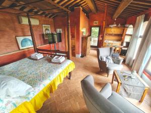 a bedroom with a bed and two chairs in a room at Residenza termale Monte Santo in San Casciano dei Bagni