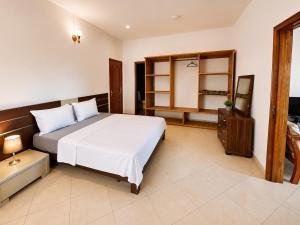ein Schlafzimmer mit einem großen weißen Bett und einem Schrank in der Unterkunft Appartement in Moroni