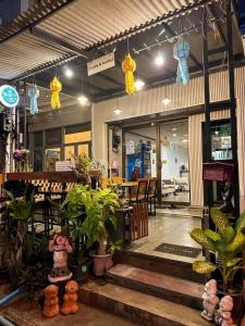 a restaurant with tables and potted plants in front of it at J Cafe & Hostel in Chiang Mai