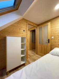 a small attic bedroom with a bed and a window at Domki hopSolina in Zawóz