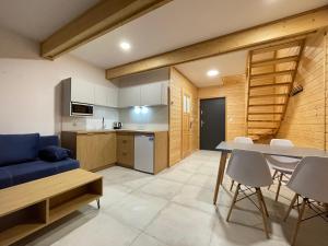 a kitchen and living room with a blue couch and a table at Domki hopSolina in Zawóz