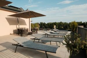 a row of chairs and umbrellas on a patio at Camoma Aparthotel - Boutique Hotel & Suites in Jesolo
