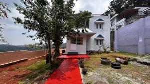 a red carpet in front of a white house at Wander homes in Ooty