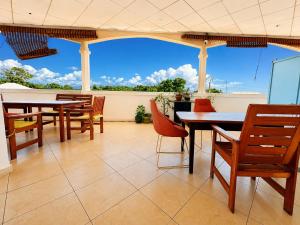 eine Terrasse mit Tischen und Stühlen und Meerblick in der Unterkunft Appartement in Moroni