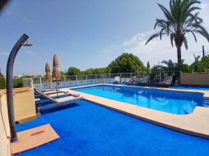 a swimming pool with blue water and palm trees at Villa Gota de Mar in Jávea