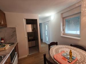 a kitchen and a dining room with a table and a window at Luminaria Solis kuća za odmor in Rogoznica