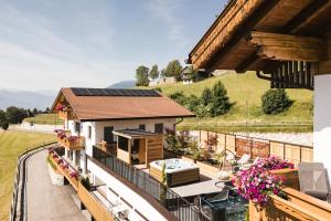a house with a balcony with a hot tub at Pension Sonnenhof in Maranza
