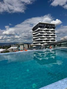 a large swimming pool in front of a tall building at Sofia Tech Park Apartments - Premium in Sofia