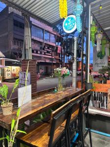 a long wooden table with chairs at a restaurant at J Cafe & Hostel in Chiang Mai