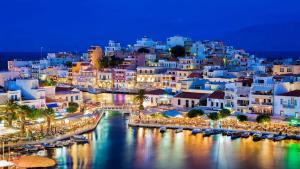 a view of a city at night with boats in the water at Ammoudi Hideaway in Agios Nikolaos