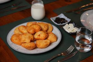 a plate of pastries on a table with a plate of milk at Velorè Boutique Hotel in Tirana +28 photos