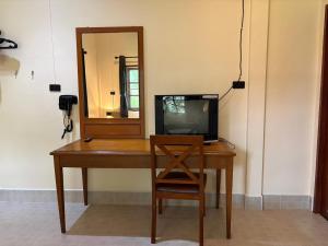 a desk with a television on it with a mirror at Coconut Bungalow in Nai Yang Beach