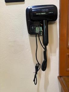 a black phone is hanging on a wall at Coconut Bungalow in Nai Yang Beach