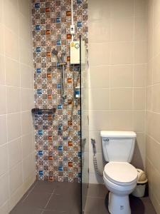 a bathroom with a toilet and a shower at Coconut Bungalow in Nai Yang Beach