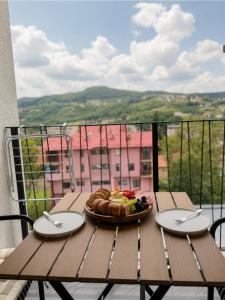 a table with a plate of food on a balcony at AURA apartment Vogošća, Sarajevo in Vogošća