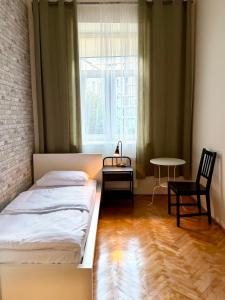 a bedroom with two beds and a table and a window at Cent Hostel - Lublin Centrum in Lublin