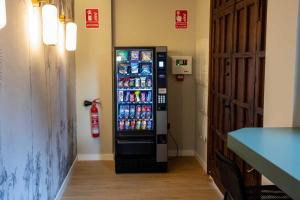 a vending machine in a room with soda cans at Alojamientos El Parque in Rute