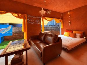 a bedroom with a bed and a leather couch at villa Morocco in Nagasaki