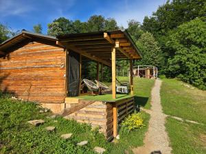 a wooden cabin with a swing and a playground at Cabana Mura in Olăneşti
