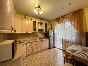 a kitchen with white cabinets and a sink and a table at Private Apartment in Morshin