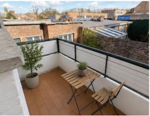 a balcony with two chairs and a table on a roof at Appartement Dunkerque cocooning centre ville in Dunkerque