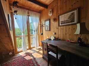 a wooden room with a desk and a large window at Gałęziówka, Doły Biskupie in Kunów