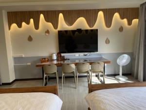 a hotel room with a table with chairs and a television at 好客來-正市區電梯別墅步行東大夜市3分鐘公正包子1分鐘 in Hualien City