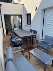 a patio with a table and chairs and a couch at Maison proximité de la plage in Plouzané