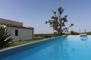 a large blue swimming pool next to a house at Casale 50 Elegante Villa a Otranto in Otranto
