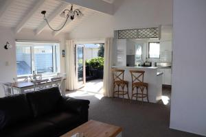 a living room with a couch and a kitchen at Beachfront Marine Parade in Mount Maunganui +19 photos