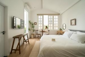 a woman sitting at a table in a bedroom at Hanachi Stay in Ho Chi Minh City