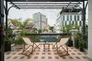 a patio with two chairs and a table on a balcony at Hanachi Stay in Ho Chi Minh City