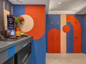 a kitchen with orange and blue walls and lockers at Guide Hotel Taipei Xinyi in Taipei