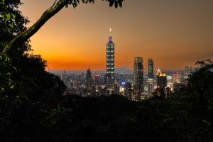 a view of a city skyline at sunset at Guide Hotel Taipei Xinyi in Taipei