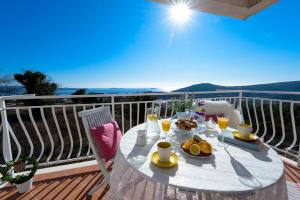 stół z jedzeniem i napojami na balkonie w obiekcie Apartment Kulisic w mieście Mlini