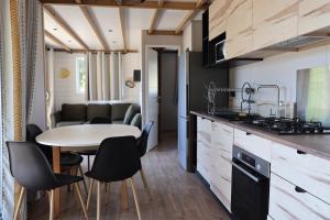 a kitchen and dining room with a table and chairs at Valterra Lodges à Châtillon-en-Diois in Châtillon-en-Diois +75 photos